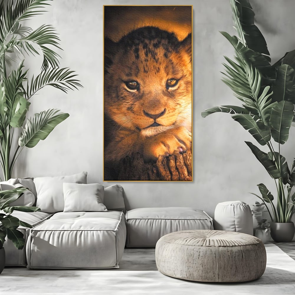 Tablou canvas cu tablou canvas cu portret de pui de leu, in rama de aluminiu auriu, pe perete intr-un living